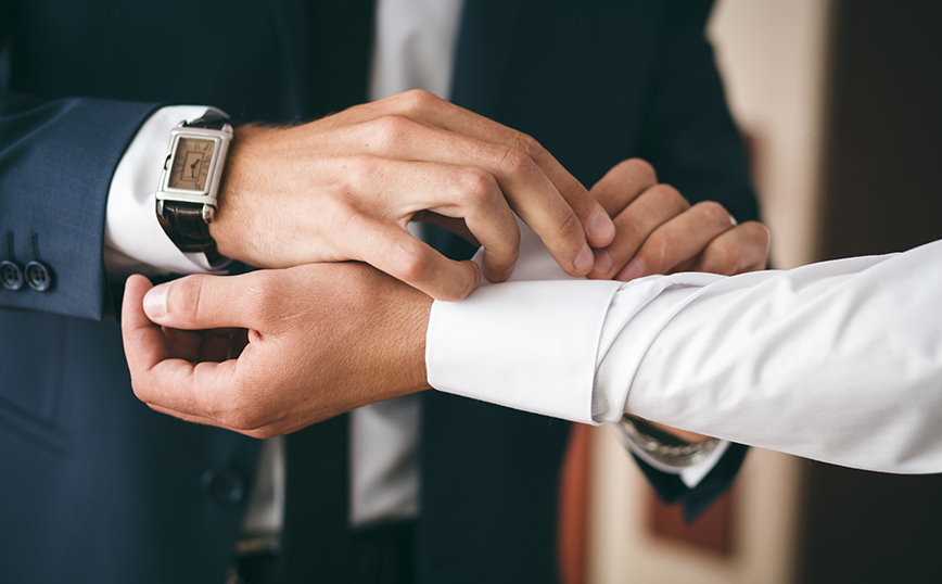 Άντρας βοηθάει κάποιον να φτιάξει τα μανικετόκουμπά του Άντρας βοηθάει κάποιον να φτιάξει τα μανικετόκουμπά του