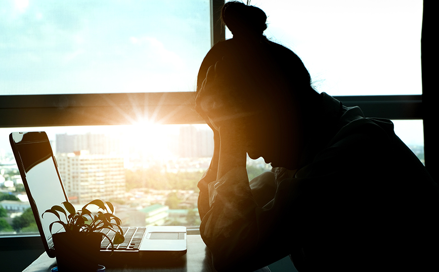 Γυναίκα με πονοκέφαλο κάθεται στο γραφείο της Γυναίκα με πονοκέφαλο κάθεται στο γραφείο της