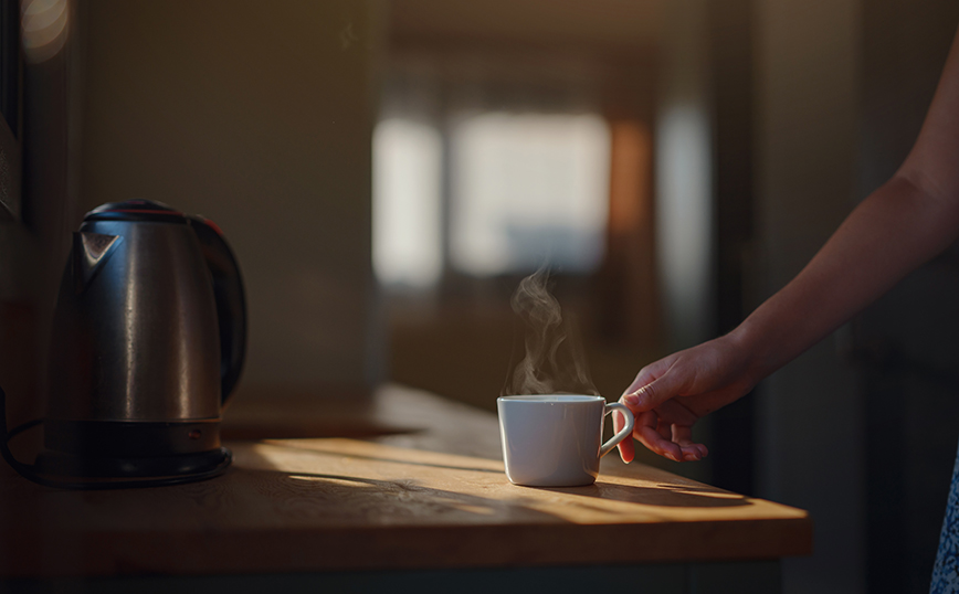 Γυναίκα πιάνει φλιτζάνι με καφέ