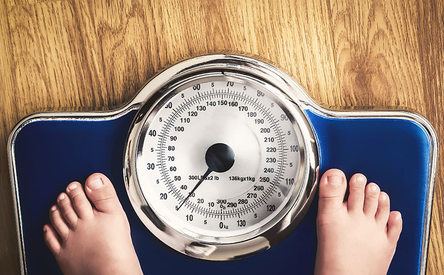 Παιδί ζυγίζεται σε ζυγαριά