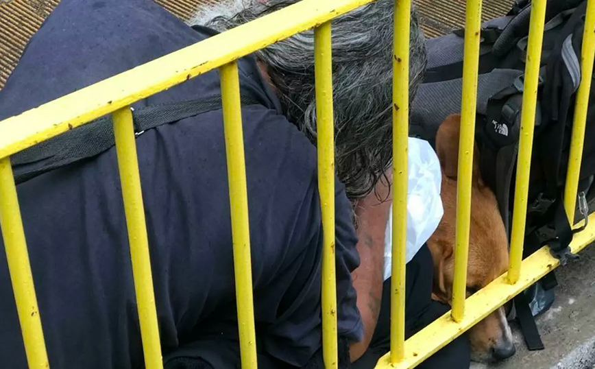 Έβρεχε και άστεγος έβγαλε το μπουφάν για να σκεπάσει το σκυλί του
