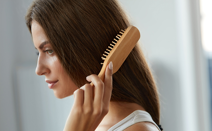 Γυναίκα χτενίζει τα μαλλιά της Γυναίκα χτενίζει τα μαλλιά της