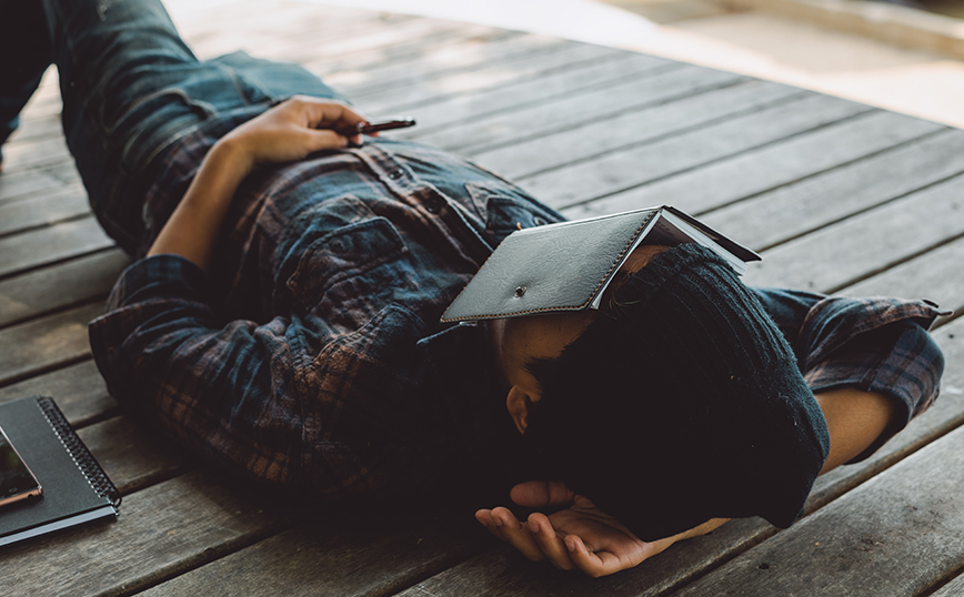 Άντρας κοιμάται με βιβλίο στο πρόσωπό του Άντρας κοιμάται με βιβλίο στο πρόσωπό του