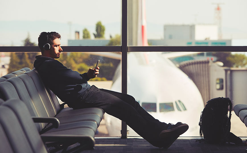 άντρας ακούει μουσική στο αεροδρόμιο άντρας ακούει μουσική στο αεροδρόμιο
