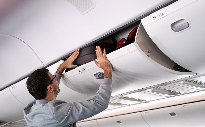 Άντρας βάζει την βαλίτσα του σε αεροπλάνο Άντρας βάζει την βαλίτσα του σε αεροπλάνο