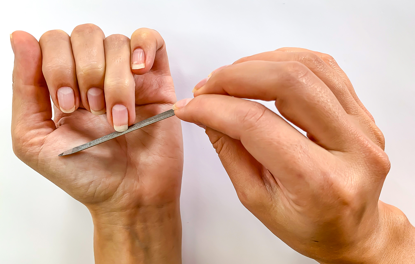 Γυναίκα λιμάρει τα νύχια της Γυναίκα λιμάρει τα νύχια της