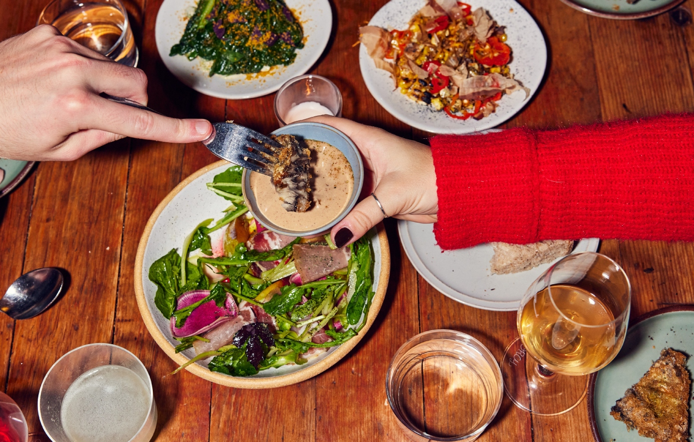 Πώς η νέα γενιά επαναφέρει μια ξεχασμένη μόδα στα τραπέζια – Η Gen Z τρώει με αγνώστους και το απολαμβάνει