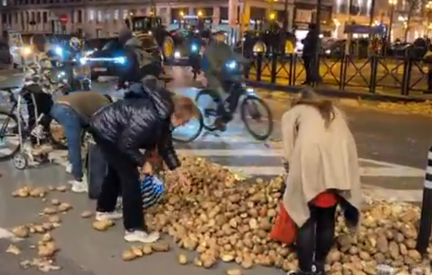 Κάτοικοι στις Βρυξέλλες μαζεύουν τις πατάτες που έριξαν οι αγρότες κατά τη διάρκεια της διαμαρτυρίας τους