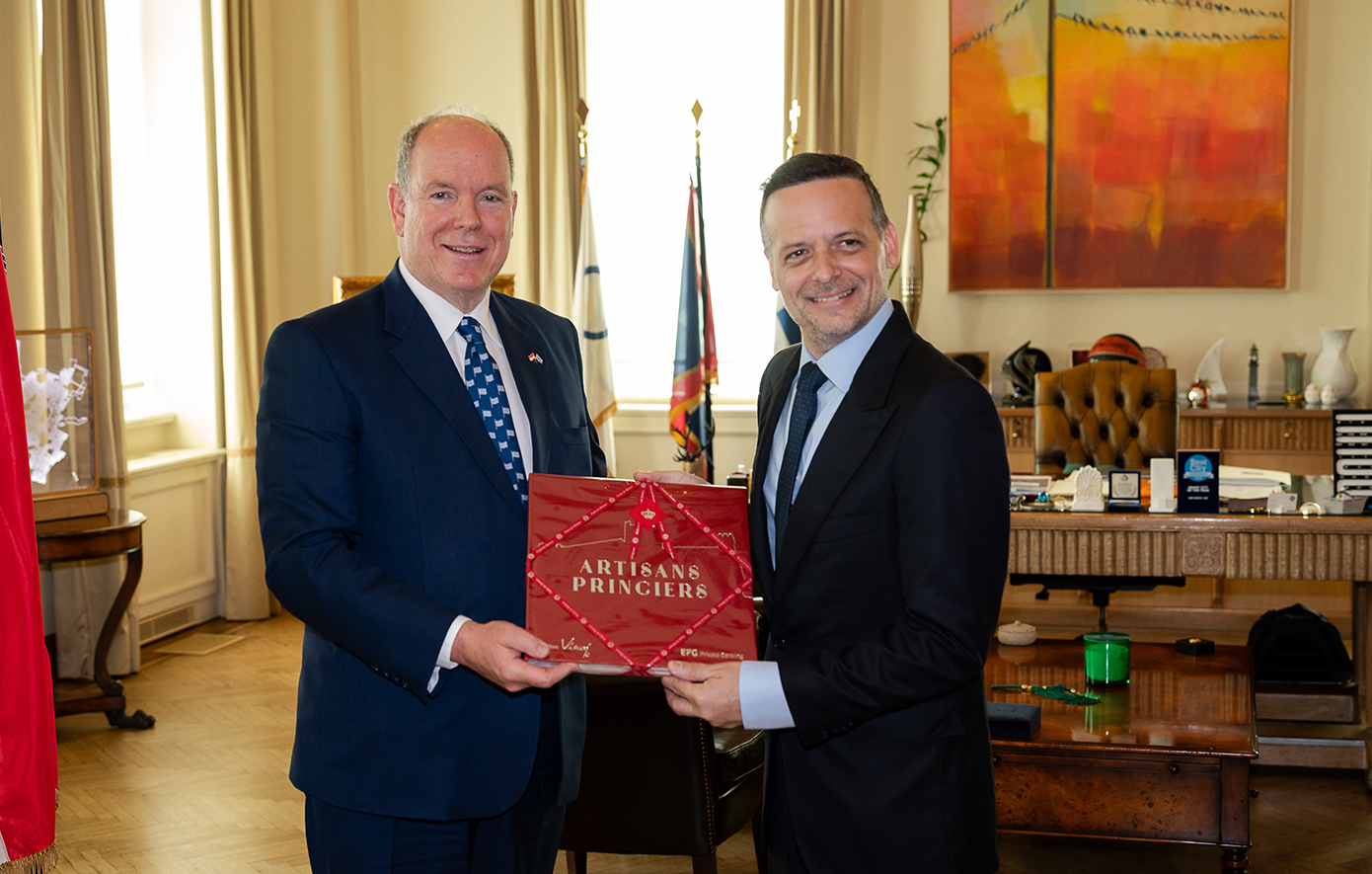 Στιγμιότυπο από το Δημαρχείο Αθηνών όπου ο Πρίγκιπας Αλβέρτος Β' προσφέρει στον Δήμαρχο Χάρη Δούκα ένα κόκκινο πολυτελές κουτί δώρου με παραδοσιακά προϊόντα του Μονακό.