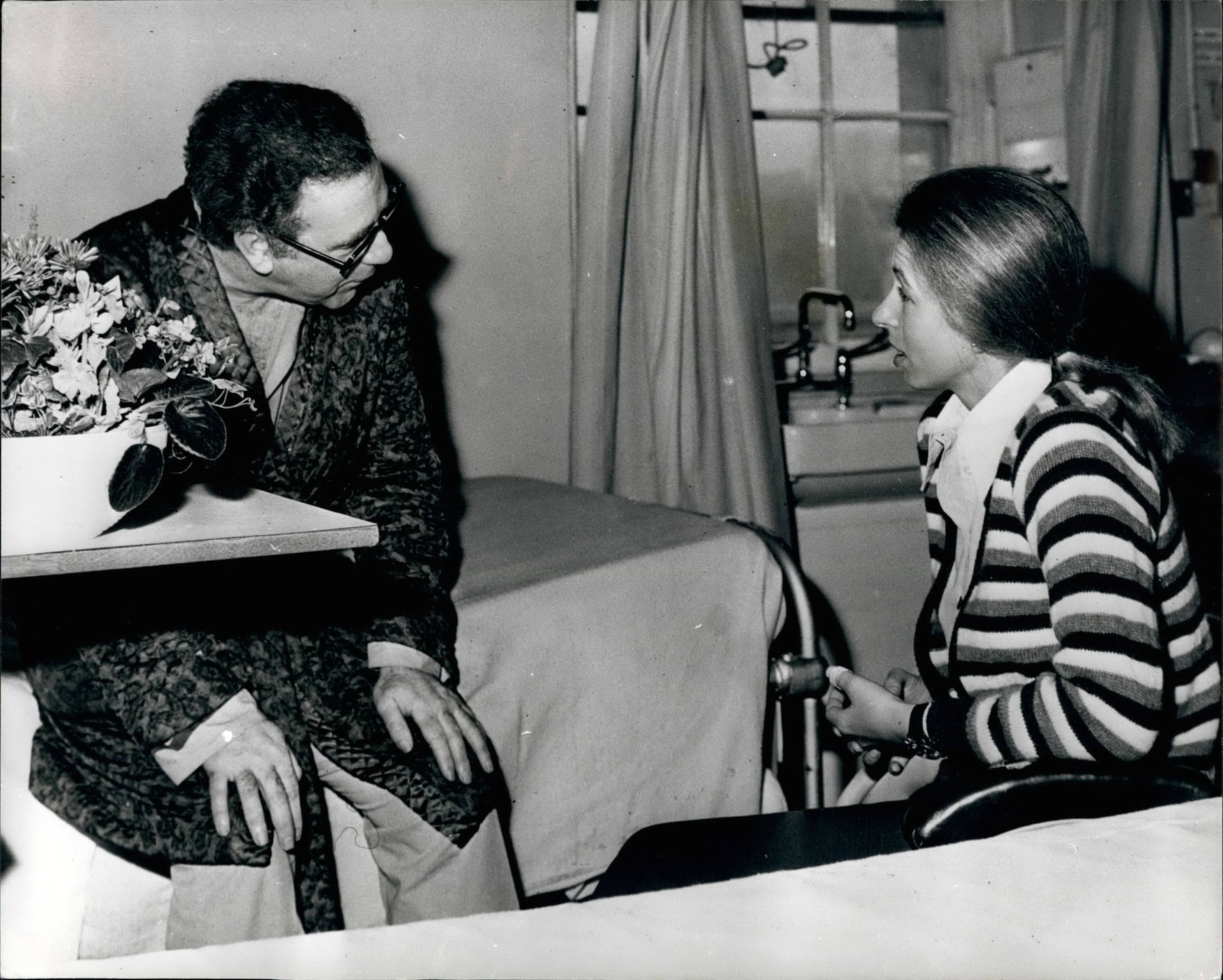 Ασπρόμαυρη ιστορική φωτογραφία από το 1974 που δείχνει την πριγκίπισσα Άννα σε θάλαμο νοσοκομείου στο Λονδίνο, να στέκεται δίπλα στο κρεβάτι του δημοσιογράφου Μπράιαν Μακόνελ και να συνομιλεί μαζί του, κατά τη διάρκεια επίσκεψής της στους τραυματίες της απόπειρας απαγωγής της. Ασπρόμαυρη ιστορική φωτογραφία από το 1974 που δείχνει την πριγκίπισσα Άννα σε θάλαμο νοσοκομείου στο Λονδίνο, να στέκεται δίπλα στο κρεβάτι του δημοσιογράφου Μπράιαν Μακόνελ και να συνομιλεί μαζί του, κατά τη διάρκεια επίσκεψής της στους τραυματίες της απόπειρας απαγωγής της.