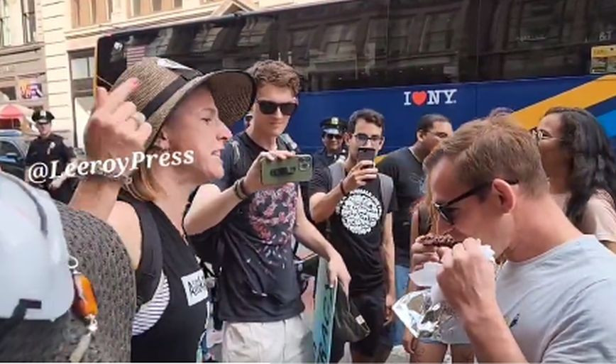Video: He casually eats his meat as animal rights activists scream in his face
