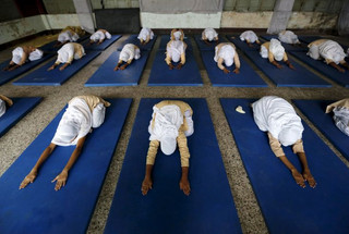 Girls practice yoga inside their school ahead of International Day of Yoga, in Ahmedabad, India, June 16, 2015. Prime Minister Narendra Modi's efforts to seize on yoga as India's signature cultural export have his Hindu nationalist allies swelling with pride, but are leaving minority religious groups feeling marginalized. REUTERS/Amit Dave
