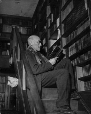 circa 1940:  Andre Paul Guillaume Gide (1869 - 1951), the French novelist and philosopher, reading a book perched on the stairs of his library. He was awarded the Nobel prize for literature in 1947.  (Photo by Hulton Archive/Getty Images)