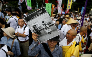 Man holds placard during anti-government rally in front of parliament in Tokyo