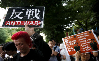 People hold placards during anti-government rally in front of parliament in Tokyo