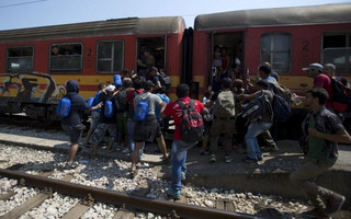 Migrants rush to board a train at Gevgelija train station in Macedonia, close to the border with Greece, August 15, 2015. In the past month, an estimated 30,000 refugees have passed through Macedonia, another step in their uncertain search for a better life in western Europe.  REUTERS/Stoyan Nenov       TPX IMAGES OF THE DAY