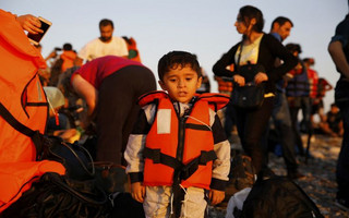 A Syrian refugee child pauses moments after arriving at a beach on the Greek island of Kos after crossing a part of the Aegean sea from Turkey to Greece on a dinghy August 13, 2015. The United Nations refugee agency (UNHCR) called on Greece to take control of the "total chaos" on Mediterranean islands, where thousands of migrants have landed. About 124,000 have arrived this year by sea, many via Turkey, according to Vincent Cochetel, UNHCR director for Europe. REUTERS/Yannis Behrakis