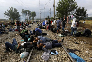 Syrian refugees sleep on rail tracks at the Greek-Macedonian border, near the village of Idomeni, August 22, 2015. Crowds of migrants and refugees were building on Greece's border with Macedonia on Saturday after a cold, wet night spent in the open, their entry slowly rationed by Macedonian police and soldiers.    REUTERS/Yannis Behrakis
