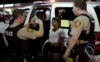 Police take a mug shot of a protester who was detained in Ferguson