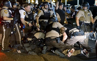Police detain a protester in Ferguson