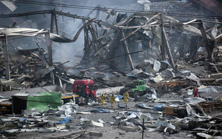 Rescue workers wearing chemical protective suits walk at the site of the explosions at the Binhai new district in Tianjin, China, August 14, 2015. Rescuers on Friday pulled one survivor from the wreckage of a warehouse in northeast China's Tianjin that was hit by two massive blasts, a city official told reporters at a briefing. REUTERS/Jason Lee