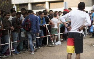 Newly arrived migrants wait in front of the State Office for Health and Social Affairs to apply for asylum in Berlin, Germany August 11, 2015. REUTERS/Stefanie Loos