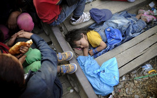 Rashida, part of a new group of immigrants, sleeps as they wait at border line of Macedonia and Greece to enter into Macedonia near Gevgelija railway station