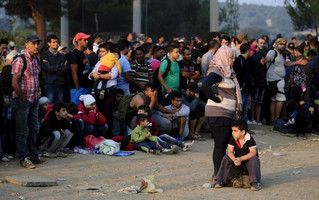 A new group of immigrants wait at the border line of Macedonia and Greece to enter into Macedonia