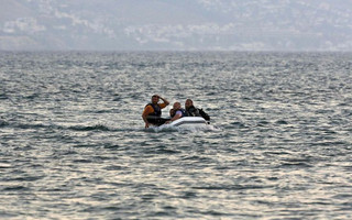 A dinghy with Syrian refugees approaches a beach of the Greek island of Kos