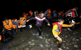 Syrian refugees jump off a dinghy as they arrive at a beach on the Greek island of Kos after crossing a part of the Aegean sea from Turkey to Greece on a dinghy August 13, 2015. The United Nations refugee agency (UNHCR) called on Greece to take control of the "total chaos" on Mediterranean islands, where thousands of migrants have landed. About 124,000 have arrived this year by sea, many via Turkey, according to Vincent Cochetel, UNHCR director for Europe. REUTERS/Yannis Behrakis
