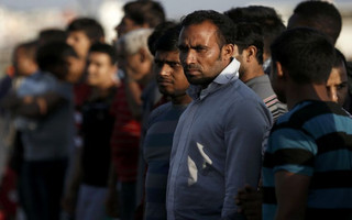 Migrants line up at the port of Kos following a rescue operation off the Greek island of Kos