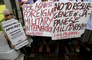 Filipino "comfort woman" survivor Tecson takes a break while holding a placard in front of the Japanese embassy in Manila
