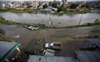 Floodwaters caused by heavy rainfall are seen among houses and slums along the swollen Bagmati River in Kathmandu