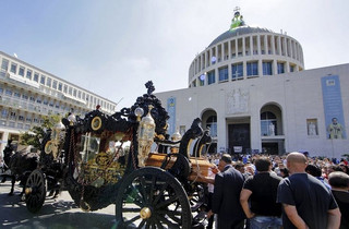 An ornate hearse pulled by six, black-plumed horses, carries the body of Vittorio Casamonica to a Roman Catholic basilica in the Rome suburbs, where the funeral mass was celebrated, August 20, 2015. Casamonica, 65, the head of a notorious Rome crime family, was given a lavish funeral on Thursday, with a helicopter dropping red rose petals on mourners and a brass band playing the theme tune from the Godfather movie. Picture taken August 20, 2015. REUTERS/Stringer      TPX IMAGES OF THE DAY