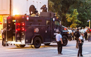 Police watch from an armoured car as protesters gathered after a shooting incident in St. Louis