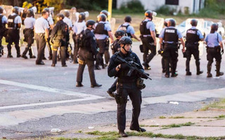 Police line up to block the street as protesters gathered after a shooting incident in St. Louis