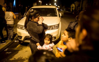 Residents stand on a street outside their houses after an earthquake hit Chile's central zone,  in Santiago