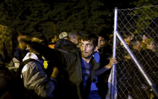 Migrants wait to enter Hungary, after the Hungarian police sealed the border with Serbia, near the village of Horgos, Serbia, September 14, 2015. REUTERS/Marko Djurica