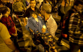 A migrant carries a child while waiting with others to enter Hungary, after the Hungarian police sealed the border with Serbia, near the village of Horgos, Serbia, September 14, 2015. REUTERS/Marko Djurica