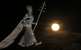 A full moon, the last of this year's supermoons, rises near a statue of Pope Leon IX in Eguisheim