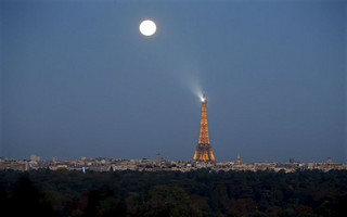 A super moon rises in the sky near the Eiffel tower as seen from Suresnes, Western Paris