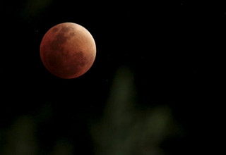 The Moon, appearing in a dim red colour, is covered by the Earth's shadow during a total lunar eclipse ove La Paz