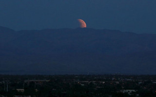 The bloodmoon is seen rising from the east over the Coachella Valley viewed from Palm Springs