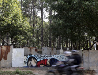 People on a motorcycle ride past a graffiti depicting the drowned Syrian toddler Aylan Kurdi in Sorocaba, Brazil, September 5, 2015. Brazil's President Dilma Rousseff criticized European nations on Friday for creating "barriers" to the entry of migrants, saying the Syrian child found on a beach in Turkey had died because he was "not welcome." Three-year-old Aylan Kurdi died along with his mother and 5-year-old brother as they attempted to cross the Mediterranean to Greece. Photographs of Kurdi, washed up dead on the shores of Turkey, shocked the world and led to a wave of criticism against the way Europe is dealing with the thousands of refugees fleeing conflict in the Middle East. The graffiti reads: "Peace, peace, peace, abandoned". Picture taken September 5, 2015.  REUTERS/Paulo Whitaker