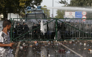 Hungarian riot police uses a water cannon against protesting migrants on the Serbian side of the border, near Roszke, Hungary September 16, 2015. Hungarian police fired tear gas and water cannon at protesting migrants demanding they be allowed to enter from Serbia on Wednesday on the second day of a border crackdown. REUTERS/Marko Djurica