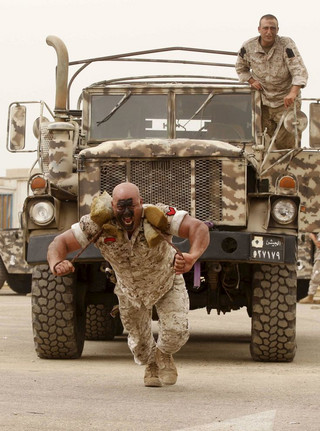 A member of the Lebanese Army's airborne regiment pulls an army truck during a live drill, held as part of a weapons exhibition during the Security Middle East Show in Beirut