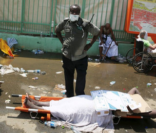 ATTENTION EDITORS - VISUAL COVERAGE OF SCENES OF INJURY OR DEATHA security officer stands near the body of a Muslim pilgrim following a crush caused by large numbers of people pushing at Mina, outside the Muslim holy city of Mecca September 24, 2015. The death toll from a stampede during the annual Muslim hajj pilgrimage in Saudi Arabia on Thursday has risen to 453 people of various nationalities, the Saudi civil defence said. REUTERS/StringerTEMPLATE OUT