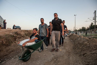 A disabled man crosses the border with his friends at Idomeni. He came to the border, carried on the back of one of his friends. He has no legs but was unable to bring his wheelchair on the boat with him when they came from Turkey to Greece.