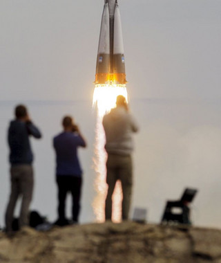 Photographers take pictures as the Soyuz TMA-18M spacecraft carrying the crew of Aidyn Aimbetov of Kazakhstan, Sergei Volkov of Russia and Andreas Mogensen of Denmark blasts off from the launch pad at the Baikonur cosmodrome, Kazakhstan, September 2, 2015.  REUTERS/Shamil Zhumatov