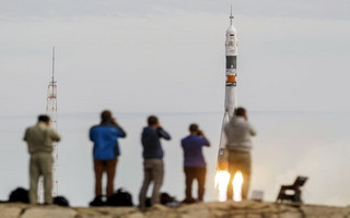 Photographers take pictures as the Soyuz TMA-18M spacecraft carrying the crew of Aidyn Aimbetov of Kazakhstan, Sergei Volkov of Russia and Andreas Mogensen of Denmark blasts off from the launch pad at the Baikonur cosmodrome, Kazakhstan, September 2, 2015.  REUTERS/Shamil Zhumatov